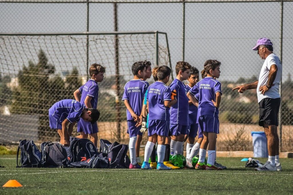 Entrenador con niños de Futbol base